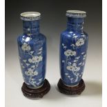 A pair of late 19th/early 20th century Chinese blue and white vases, 30.5cm high, with wood stands