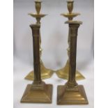 A pair of 18th century bell metal pillar candlesticks and a pair of 19th century brass