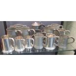 A collection of fourteen pewter beer mugs and a tankard