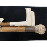 A ball topped walking cane together with two stag's horn handled walking sticks