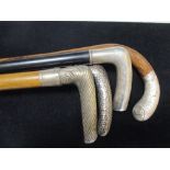 Four white metal handled walking sticks, '800' and other marks