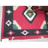 A modern Kelim style rug in red, green, black and cream, 183 x 118cm
