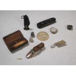 A small collection of items to include a silver pincushion, thimbles, a cheroot holder and an 1883