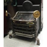 A cast iron fire grate, with brass mounted finials  This is a reproduction.