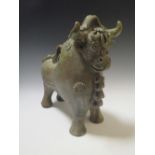 A Continental pottery figure of a stylised bull, a 20th century bronze figure in the manner of