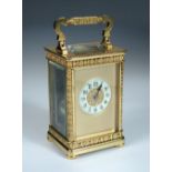 A French gilt brass carriage clock with floral banded decoration, the typical shape case Arabic