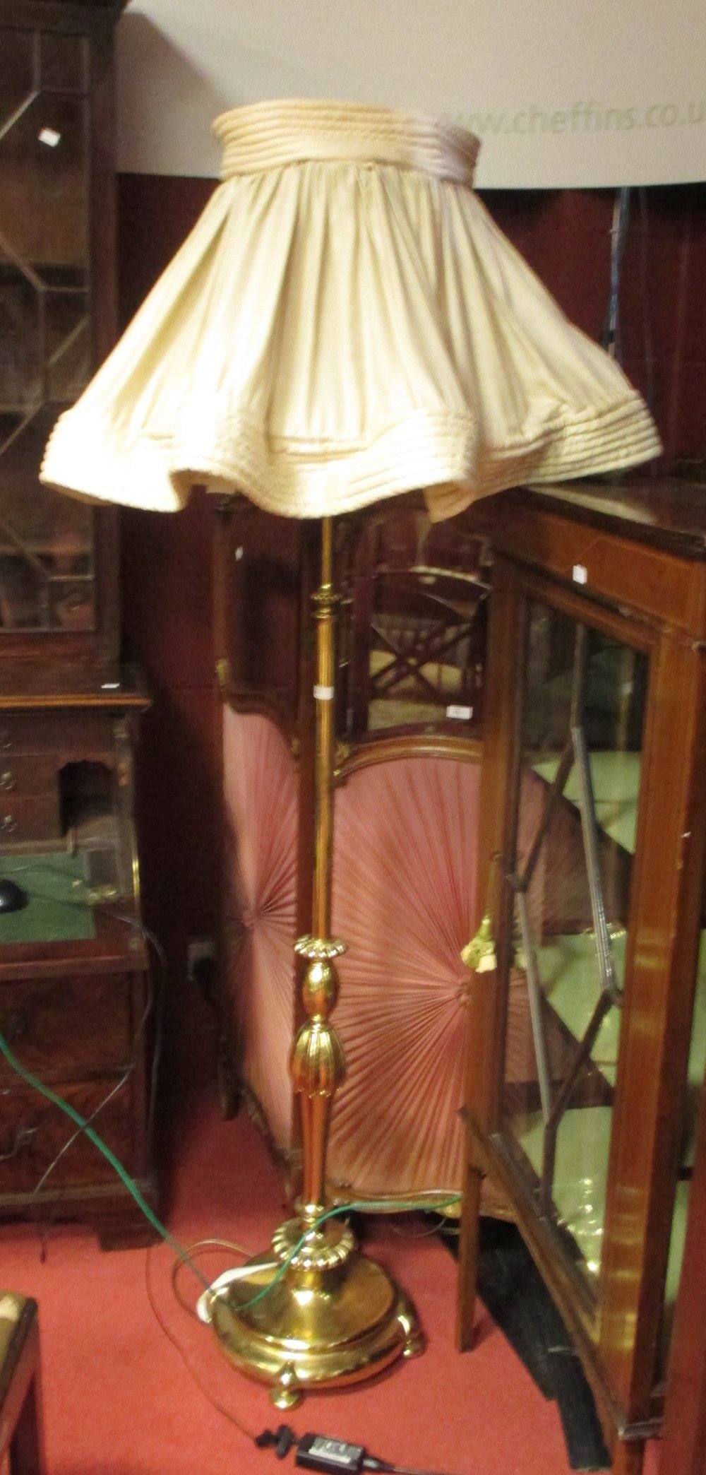 A brass standard lamp and shade