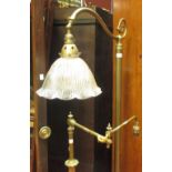 An early 20th century brass floor standing adjustable lamp, together with another similar