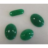 A collection of four green jadeite cabouchons