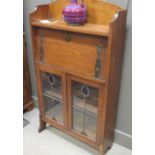 An Edwardian oak upright bureau, with copper strap hinges and stained glass glazed doors below,