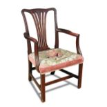 A Hepplewhite mahogany elbow dining chair, with husk and leaf carved back, needlepoint seat, on