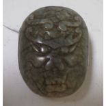 A Chinese spinach green jade belt buckle carved with a dragon's head