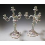 A pair of German porcelain three branch candelabra, floral decoration