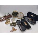 A quantity of badges, buttons, spectacles and two clocks