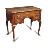 A George III oak lowboy, with shaped fret carved apron, later brass plate handles, on slender