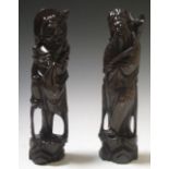 A pair of Chinese wire inlaid hardwood figures of immortals, 29cm high