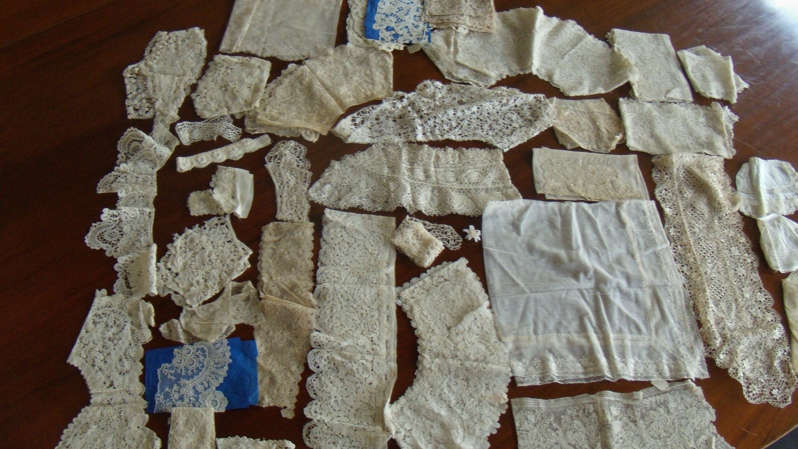 A box of lace collars, three caps, lace tape and panels