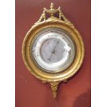 An aneroid wall barometer in a gilt frame