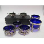A cased pair of English salts with glass liners, another pair European and a set of three others