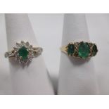 An emerald and diamond cluster ring, the central oval emerald with diamond cluster surround and