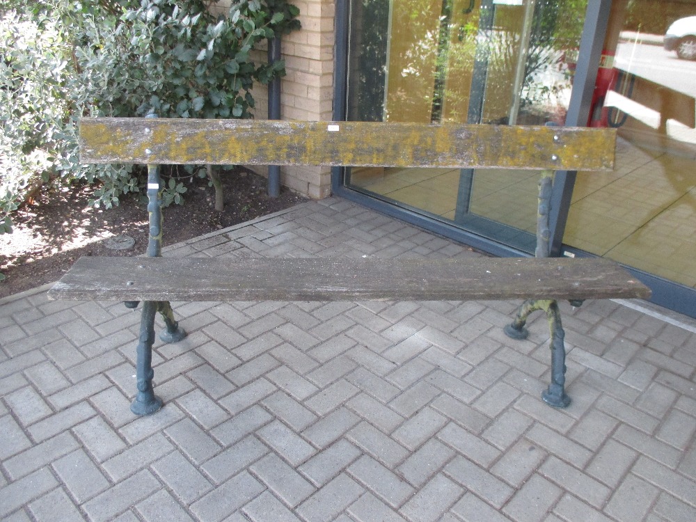 A cast iron garden bench with single plank seat