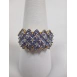 A pale lavendar coloured ring, probably tanzanites, set in five rows and interspaced with small