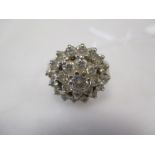 An 18ct white gold diamond cluster ring, the central round brilliant cut diamond surrounded by two