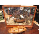 A model of a Hastings Punt in glass case, and a small model rowing boat