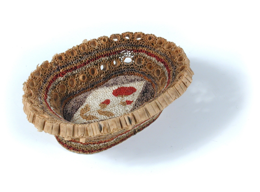 An early 19th century paper filigree basket, with central floral motif and looped handle to one end,