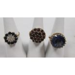 A 9ct garnet cluster ring, a 9ct sapphire and diamond ring and a sapphire doublet ring stamped 9k (