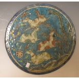 A circular Persian glazed plaque with crackle glaze, painted with four deer (?) in a landscape, 37cm