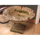 A stone circular planter on pedestal base