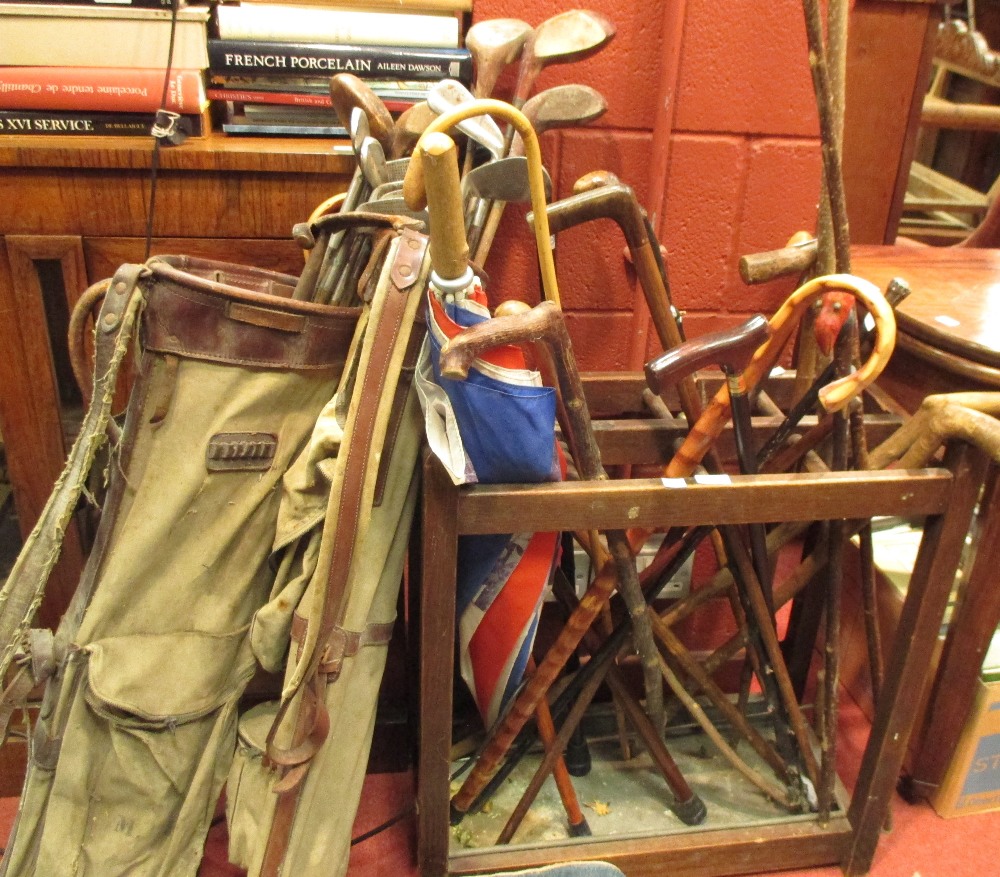 A stick stand, sword, sticks and two bags of golf clubs