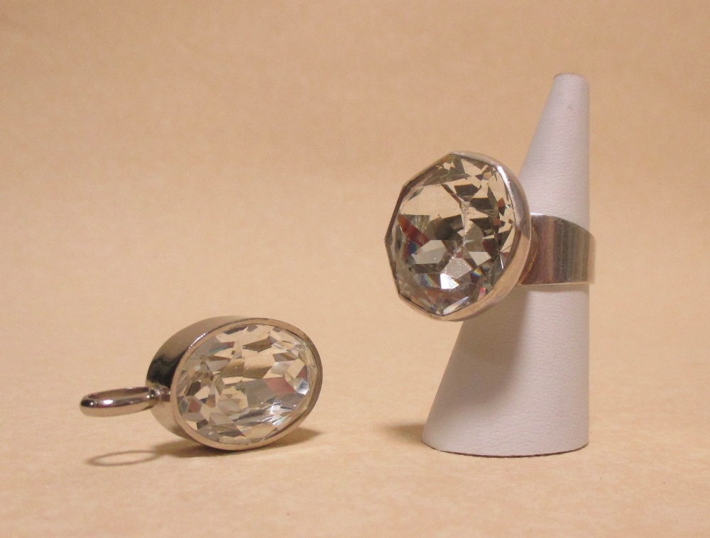 A contemporary rock crystal ring and similar pendant both set in unmarked white metal (2)
