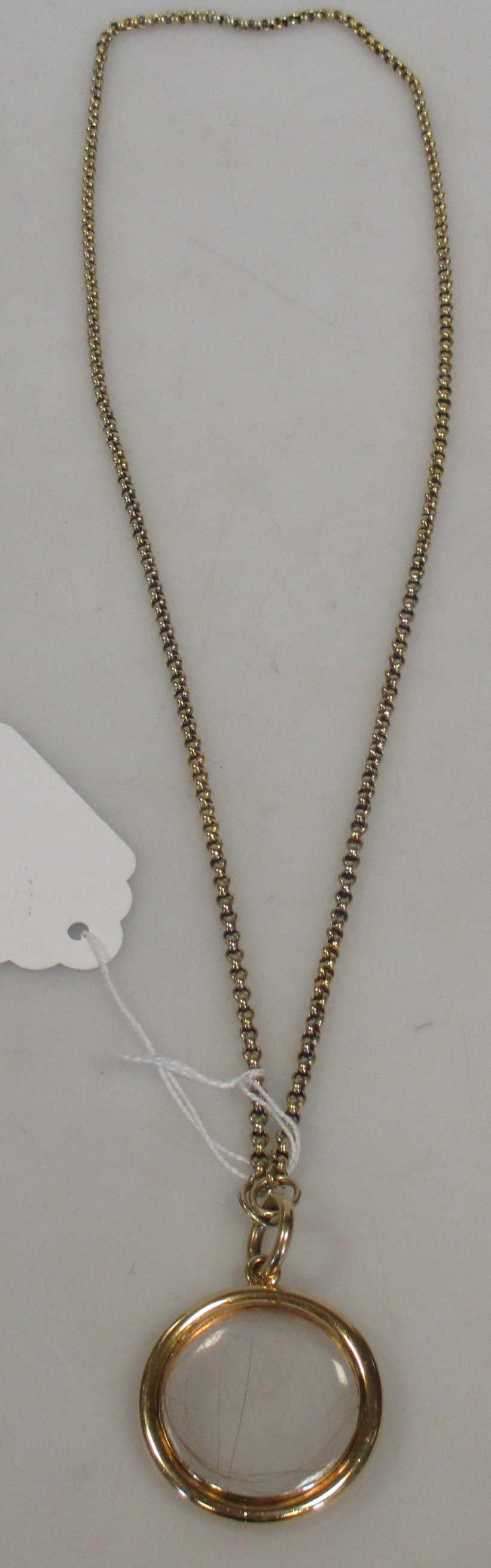 A double-sided vitrine pendant with yellow metal chain, gross 29g