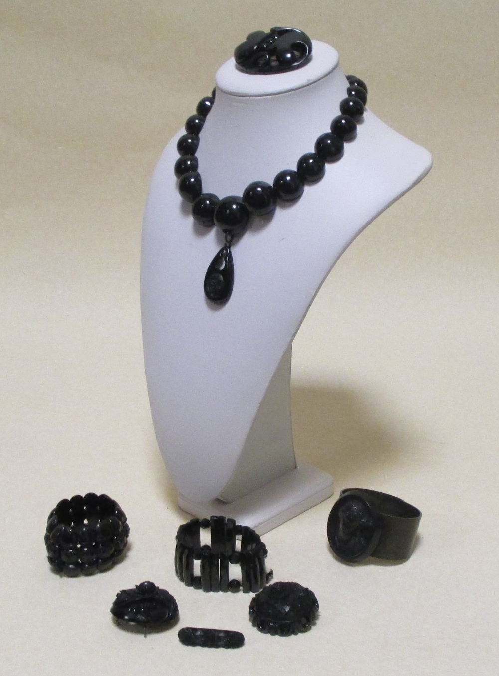 A group of jet jewellery to include a necklace, three brooches, two bracelets and a cameo style cuff