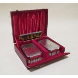 A cased pair of silver backed hair brushes and a comb