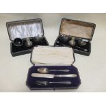 Two cased silver cruet sets and a cased silver knife, fork and spoon set