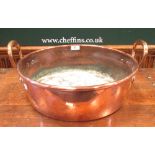 A copper lidded pan, together with a copper jam pan and a brass tray top table