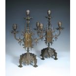 A pair of 19th century gothic bronze candelabra, each with three branch lights to an arched centre