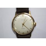 By Baume - a gentleman's 9ct gold cased wristwatch, the white dial with gold coloured baton numerals