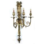 A pair of gilt metal three-branch wall lights, each with bow tied ribbon and foliate back plates,