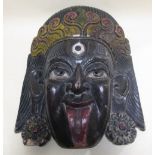 A polychrome carved wood mask of Khali, 50cm high