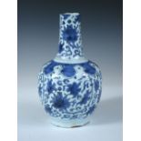 A mid 18th century Delft blue and white bottle vase painted in two tones of blue with scrolling