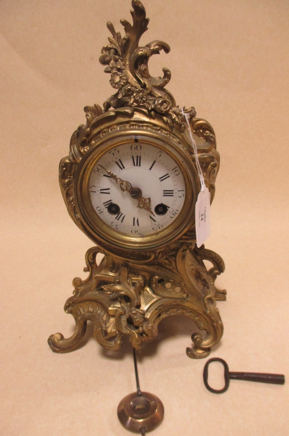 A late 19th/early 20th century French ormolu mantel clock, pendulum and key, 29cm high