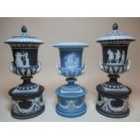 A pair of Wedgwood black jasper urns and covers together with another urn in blue jasper, tallest