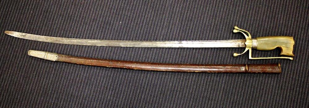 An Arabian nimcha (curved bladed sword) with brass mounted horn handle, plain steel blade, and - Image 3 of 3