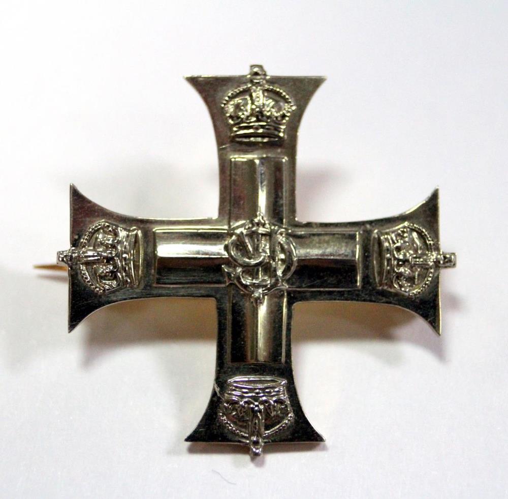 A silver and gold coloured brooch formed as a miniature Military Cross, associated with the Military