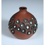 A small Poole stoneware vase by Guy Sydenham, with carved and glazed repeated circular patterns,