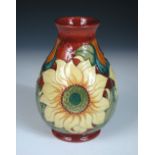 A Moorcroft Sunflower pattern vase, decorated to a red ground, painted and impressed marks, dated (